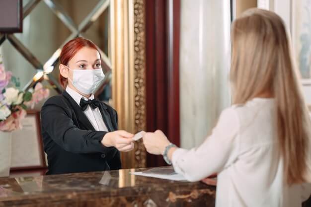 check-hotel-receptionist-counter-hotel-wearing-medical-masks-as-precaution-against-virus-young-woman-business-trip-doing-check-hotel_109285-8737
