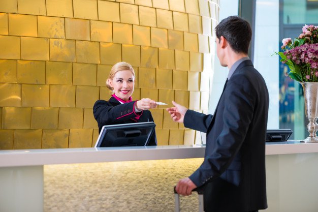 hotel-receptionist-check-man-giving-key-card_79405-1509
